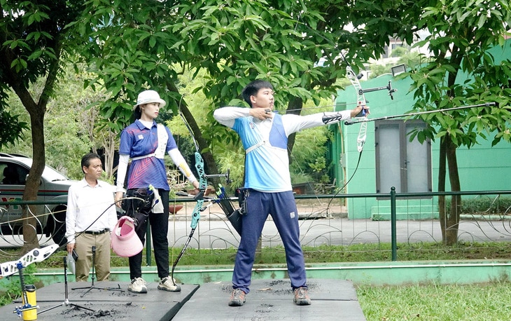 Hai cung thủ Lê Quốc Phong và Đỗ Thị Ánh Nguyệt tập luyện - Ảnh: HOÀNG TÙNG