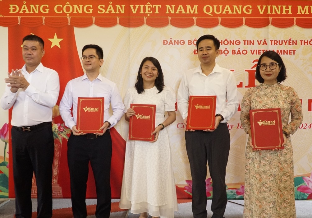 Bí thư Đảng bộ, Tổng biên tập Báo VietNamNet trao quyết định kết nạp đảng viên mới cho quần chúng ưu tú.