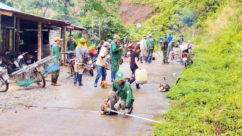 Cán bộ, chiến sĩ Đồn Biên phòng Ia Dom cùng người dân phát quang bụi rậm khu vực đường biên, cột mốc. 