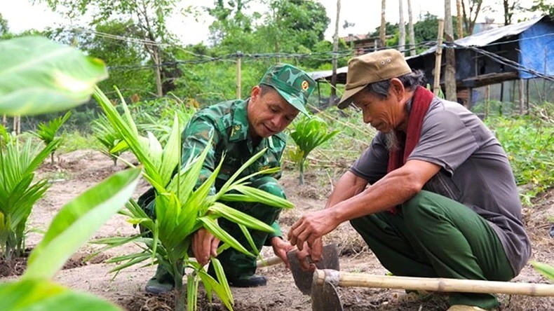 Cán bộ Đồn Biên phòng Dục Nông (Bộ Chỉ huy Bộ đội Biên phòng tỉnh Kon Tum) hướng dẫn người dân canh tác cây trồng. (Ảnh: MAI HƯƠNG)