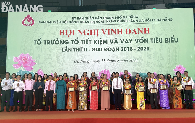 Lãnh đạo thành phố tặng hoa và bằng khen cho các tổ trưởng tổ tiết kiệm và vay vốn tiêu biểu. Ảnh: M.Q