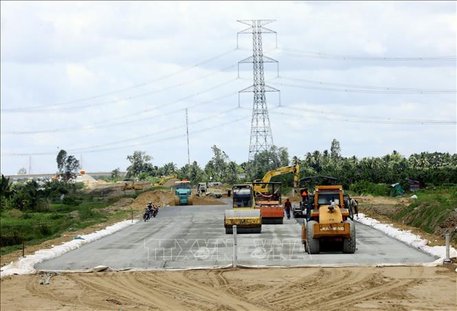 Các nhà thầu đang tập trung thi công trải thảm bê tông nhựa trên đoạn tuyến tuyến cao tốc Mỹ Thuận - Cần Thơ. Ảnh: Huy Hùng/TTXVN