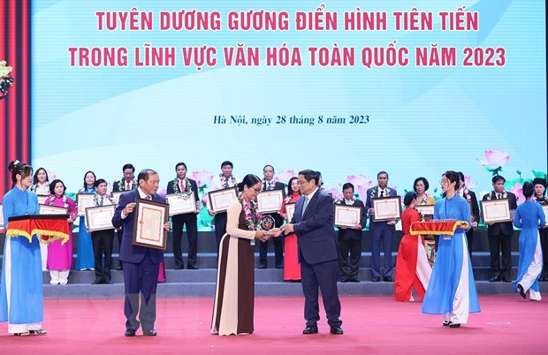 Thủ tướng Phạm Minh Chính trao biểu trưng vinh danh các gương điển hình tiên tiến trong lĩnh vực văn hóa. (Ảnh: Dương Giang/TTXVN)