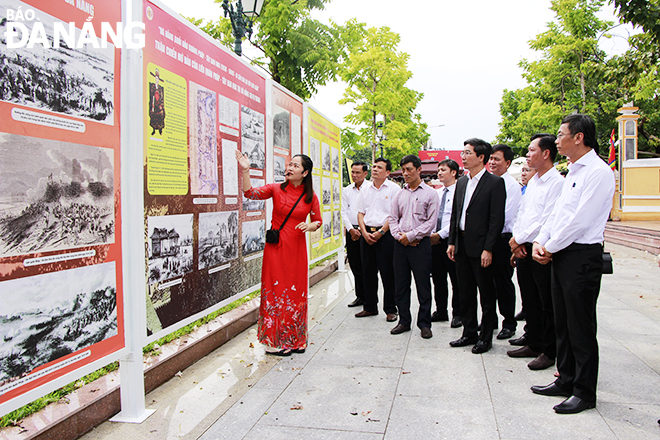 Các đại biểu tham quan và nghe thuyết minh về các hình ảnh trưng bày tại triển lãm. Ảnh: X.D