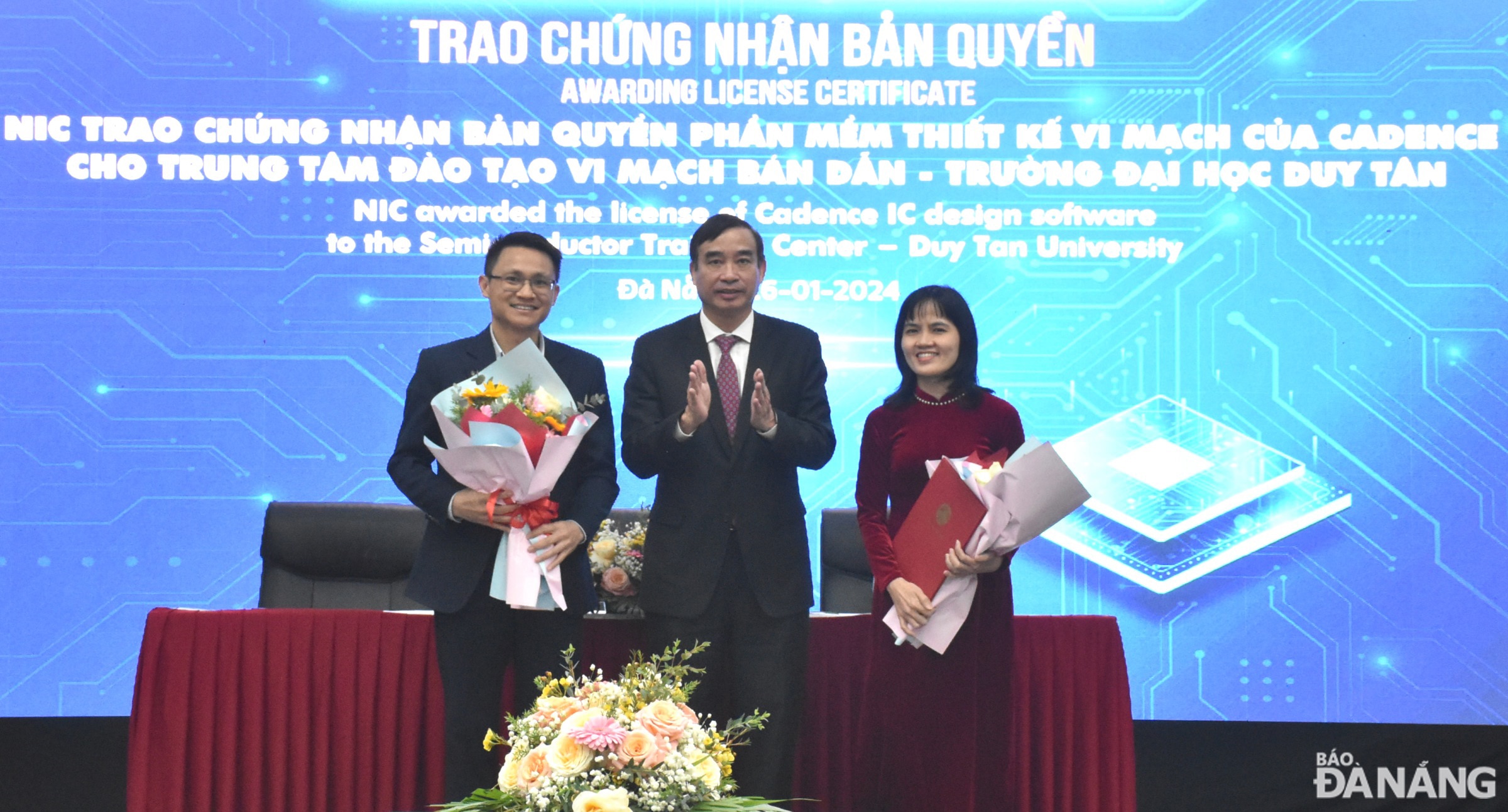 Chủ tịch UBND thành phố Lê Trung Chinh (giữa) trao hóc chúc mừng Trung tâm đào tạo vi mạch bán dẫn của Trường Đại học Duy Tân được nhận giấy chứng nhận bản quyền phần mềm thiết kế vi mạch của Cadence. Ảnh: HOÀNG HIỆP - THU HÀ