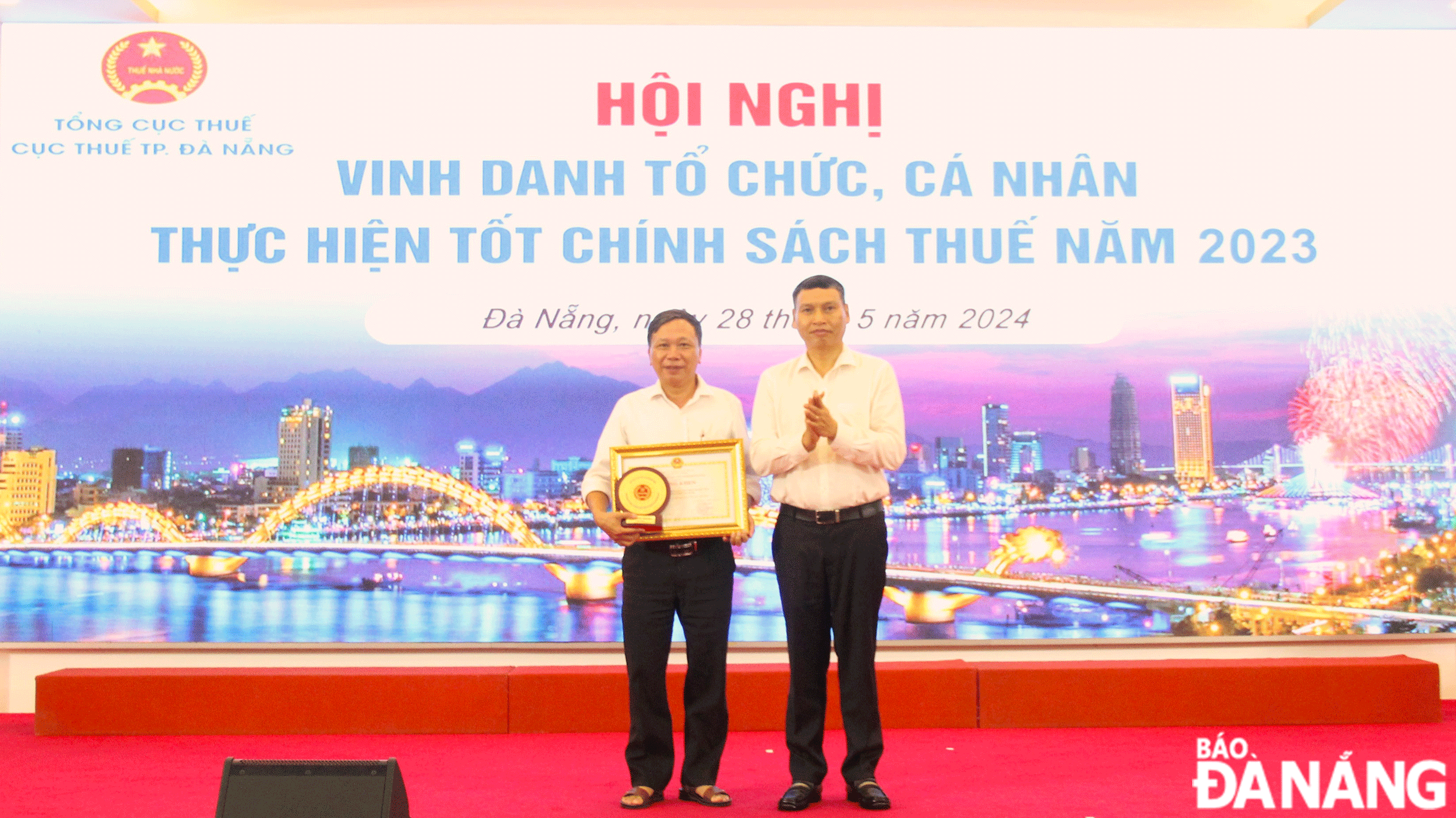 Phó Chủ tịch Thường trực UBND thành phố Hồ Kỳ Minh (bên phải) trao bằng khen của UBND thành phố cho đại diện tổ chức chấp hành tốt chính sách thuế năm 2023. Ảnh: M.Q	