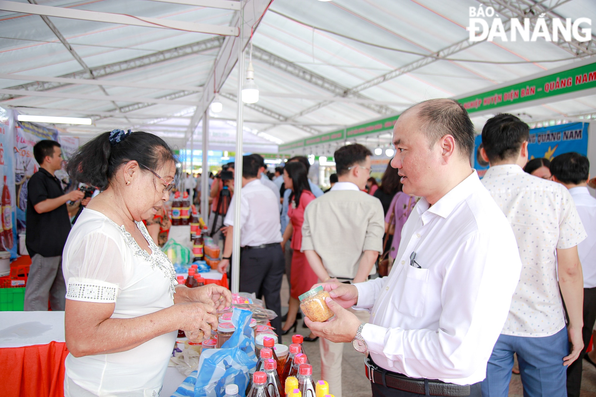 Phó Chủ tịch UBND quận Liên Chiểu Trần Công Nguyên (áo trắng) trao đổi thông tin với chủ hộ kinh doanh nước mắm Nam Ô.