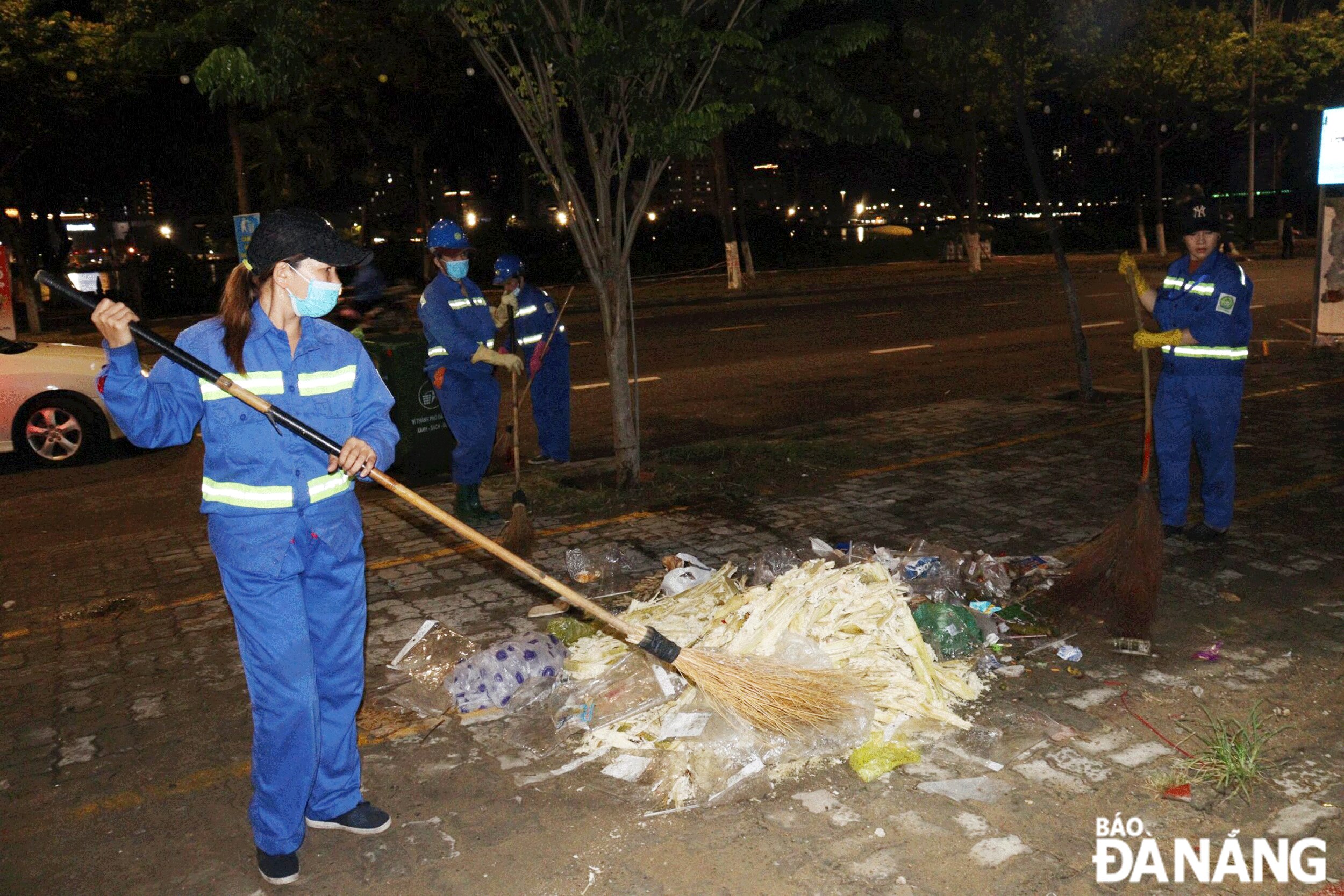 Công nhân Xí nghiệp Môi trường Sơn Trà dọn rác sau kết thúc thi trình diễn pháo hoa.  Ảnh: HOÀNG HIỆP