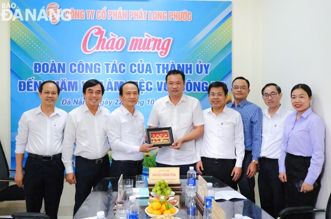 Phó Bí thư Thường trực Thành ủy Nguyễn Đình Vĩnh (thứ 3, trái qua) tặng quà lưu niệm cho đại diện Công ty CP Phát Long Phước. Ảnh: M.Q