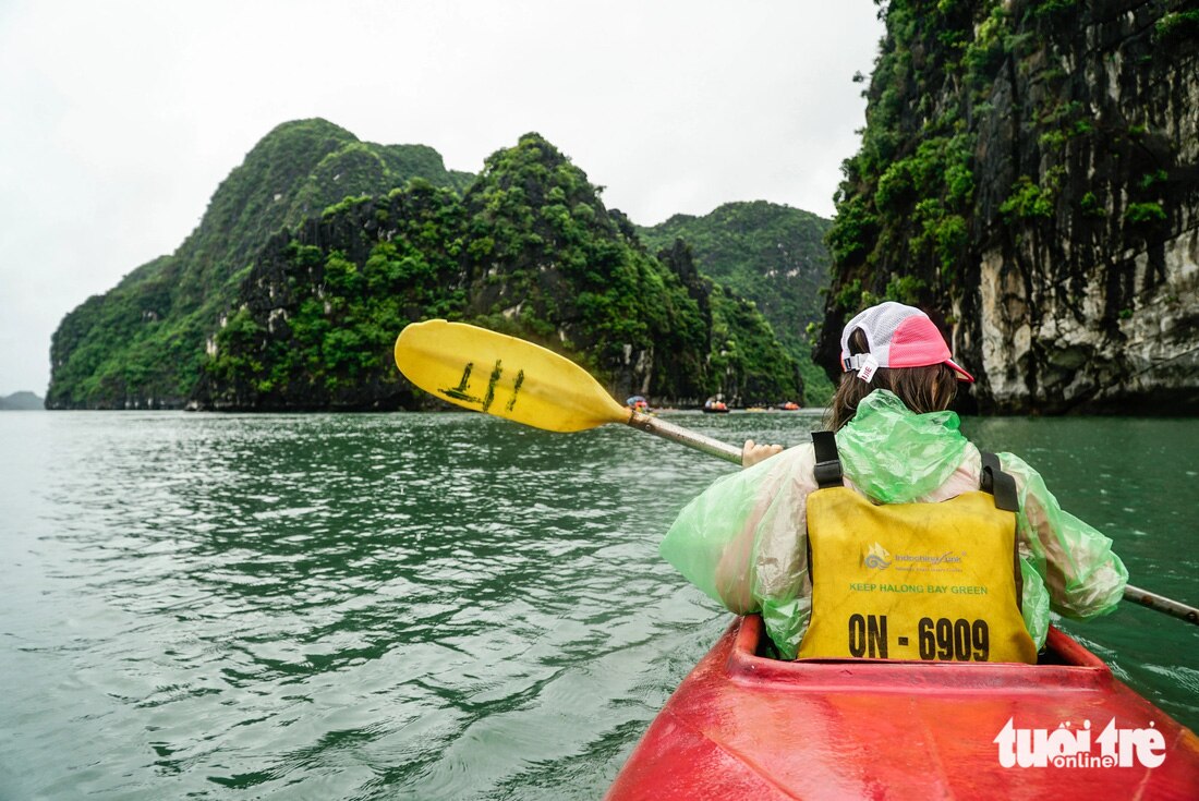 Lối nhỏ giữa hai núi đá phía trước là luồng nước mạnh, xiết. Du khách cần chèo mạnh, đều tay để vượt qua thử thách nhỏ trong chuyến khám phá làng chài - Ảnh: NGUYỄN HIỀN