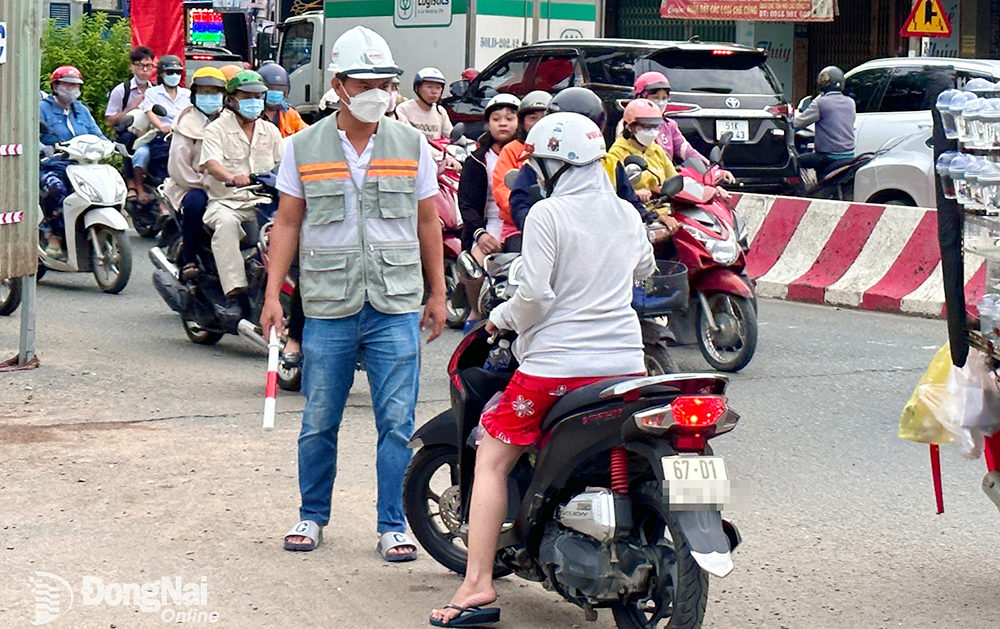 Một người đi xe máy ngược chiều ngay rào chắn đã bị đơn vị thi công chặn lại, hướng dẫn quay đầu để tránh nguy hiểm