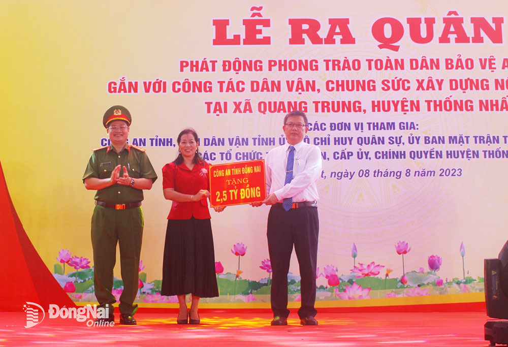 Đại diện lãnh đạo UBND H.Thống Nhất nhận bảng tượng trưng kinh phí hỗ trợ các hoạt động dân vận từ đại tá Trần Anh Sơn, Phó giám đốc Công an tỉnh