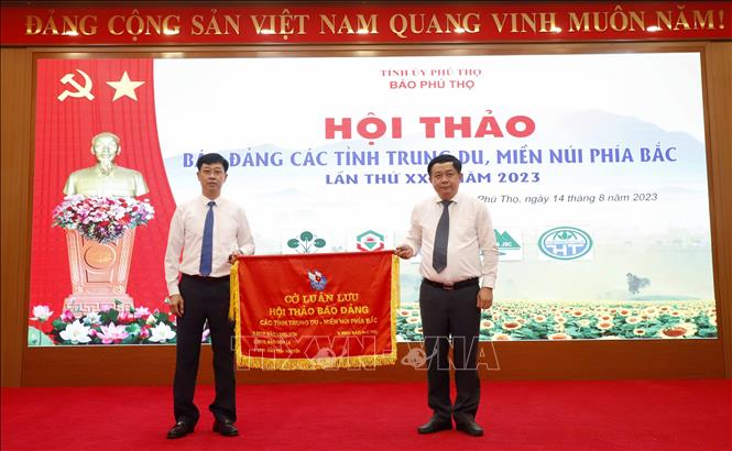 Tổng biên tập Báo Phú Thọ Vũ Xuân Chường trao Cờ đăng cai tổ chức Hội thảo năm 2024 cho Giám đốc, Tổng biên tập Trung tâm truyền thông tỉnh Quảng Ninh Mai Vũ Tuấn. Ảnh: TTXVN