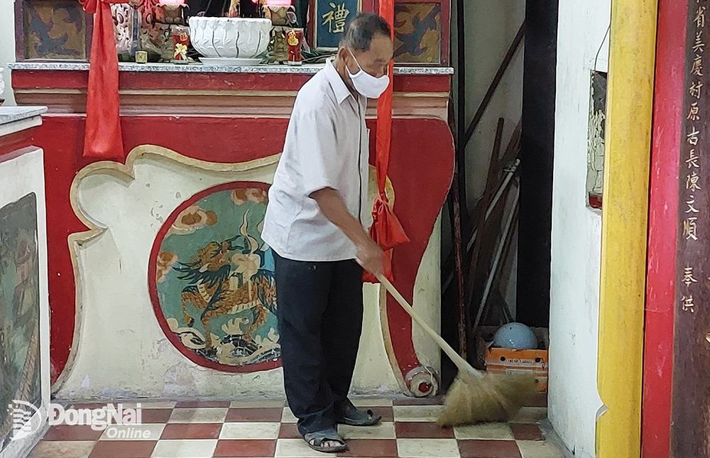 Ông Phạm Văn Hê, Phó ban Quý tế đền thờ Nguyễn Tri Phương (TP.Biên Hòa) quét dọn vệ sinh môi trường trong khuôn viên di tích. Ảnh: L.NA