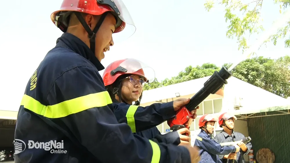 Các em học sinh được thực hành các thiết bị, dung cụ chữa cháy. Ảnh: Hải Đình