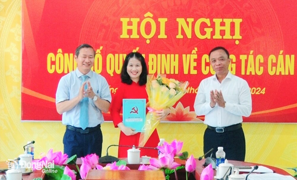 Lãnh đạo Huyện ủy Thống Nhất trao quyết định và tặng hoa chúc mừng đồng chí Nguyễn Thị Hồng Gắm. Ảnh: T.Thụ