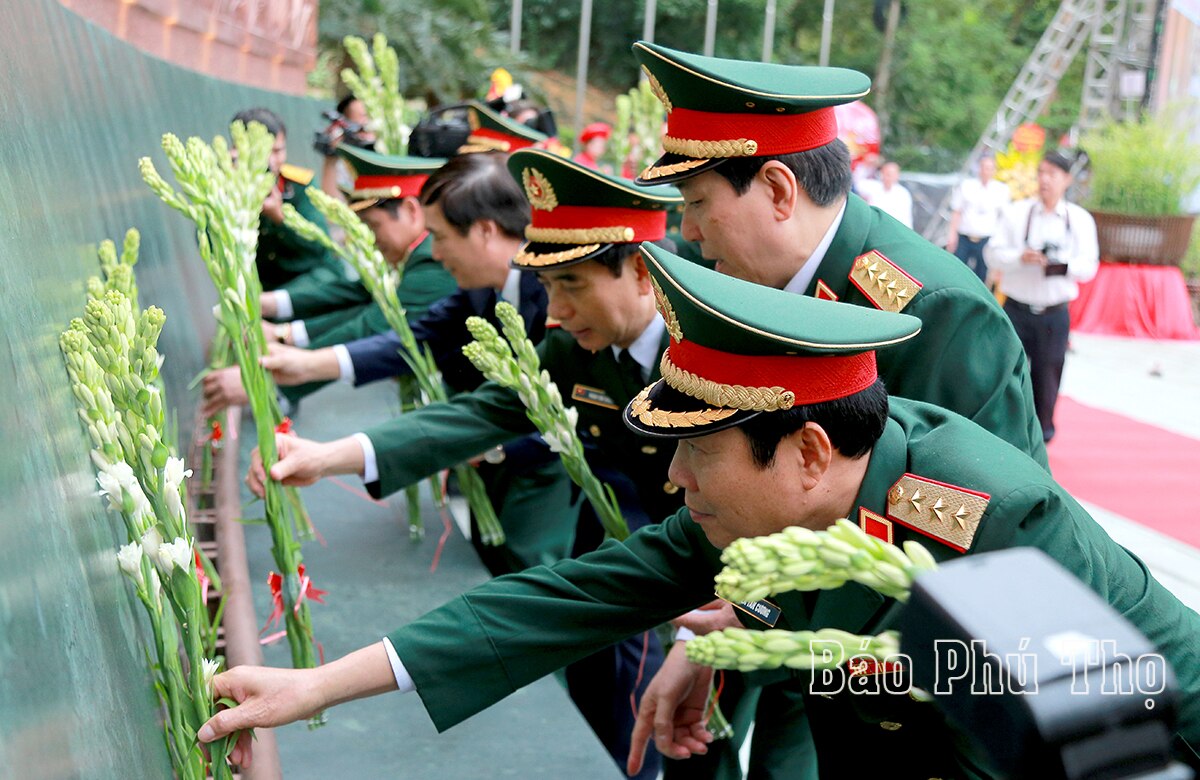 Các đại biểu dâng hoa tại bức phù điêu

