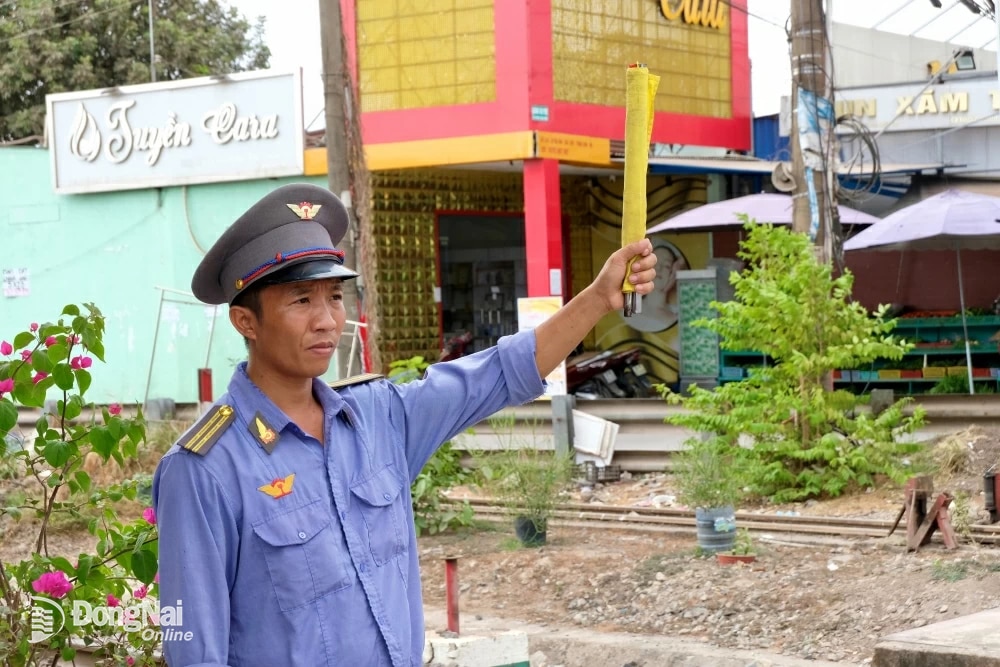 Vào ban ngày, nhân viên chốt gác sẽ dùng cờ để báo hiệu cho đoàn tàu; vào ban đêm sẽ là đèn cầm tay. Ảnh: Đăng Tùng