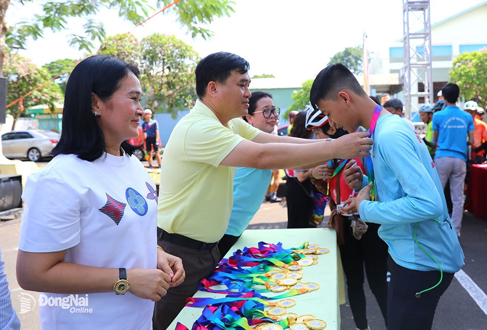 Lãnh đạo tỉnh, hai thành phố: Biên Hòa, Long Khánh trao kỷ niệm chương cho các vận động viên hoàn thành lộ trình diễu hành từ thành phố Biên Hòa đi tới thành phố Long Khánh. Ảnh: Huy Anh 