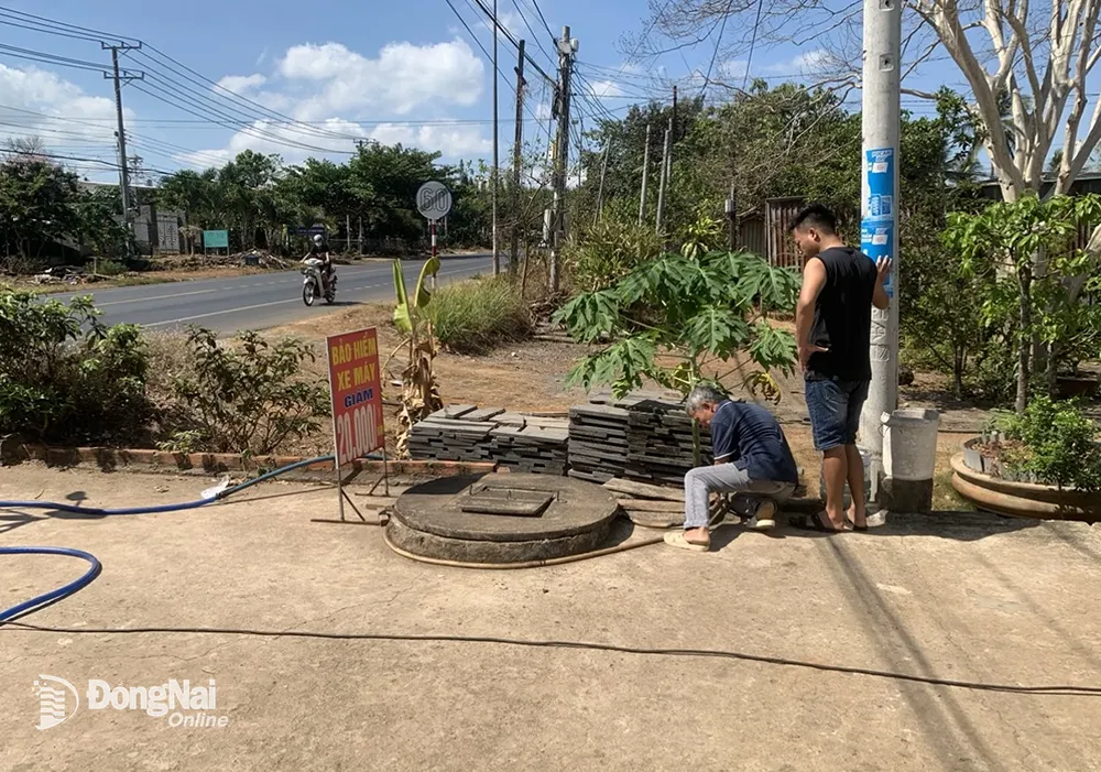 Đấu nối đường ống để bơm nước từ xe chở nước lên bồn cho từng hộ gia đình tại xã La Ngà. Ảnh: ĐVCC