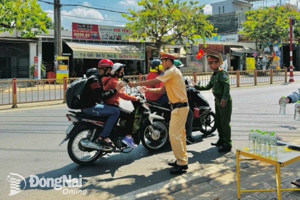 Đội Cảnh sát giao thông - trật tự Công an thành phố Long Khánh “tiếp sức” nước suối cho người dân vào ngày đầu nghỉ lễ. Ảnh: CTV