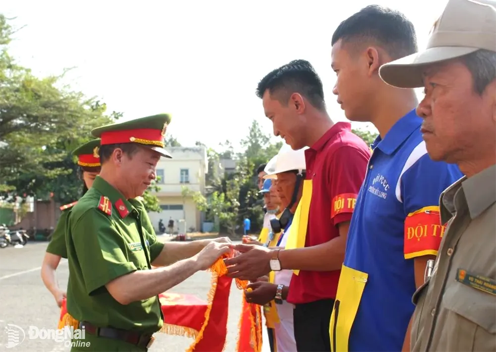 Trưởng công an thành phố Biên Hòa, thượng tá Huỳnh Yên Nam trao cờ lưu niệm cho các đội tham gia hội thi. Ảnh: Tố Tâm
