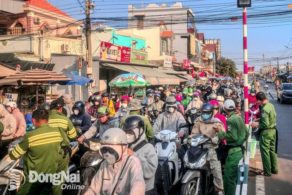 Người đi xe máy xếp hàng mua vé chờ lên phà Cát Lái (huyện Nhơn Trạch) trong thời tiết nắng nóng. Ảnh: Lê Duy