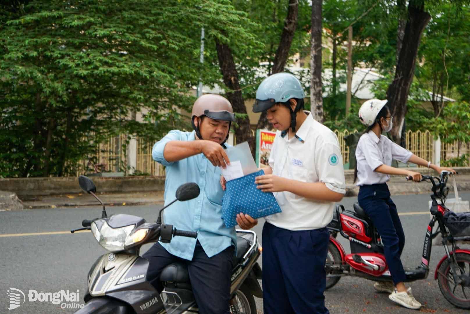 Phụ huynh lo lắng kiểm hỗ trợ học sinh kiểm tra đầy đủ giấy tờ để bước vào làm thủ tục thi tại Trường trung học phổ thông chuyên Lương Thế Vinh (đường Lê Quý Đôn, phường Tân Hiệp). Ảnh: Lê Duy