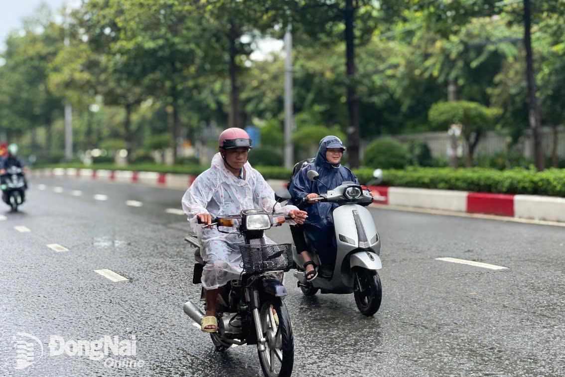 Người dân di chuyển trong thời tiết mưa, gió trên đường Đồng Khởi (phường Tân Hiệp, thành phố Biên Hoà). Ảnh minh họa: Lê Duy.