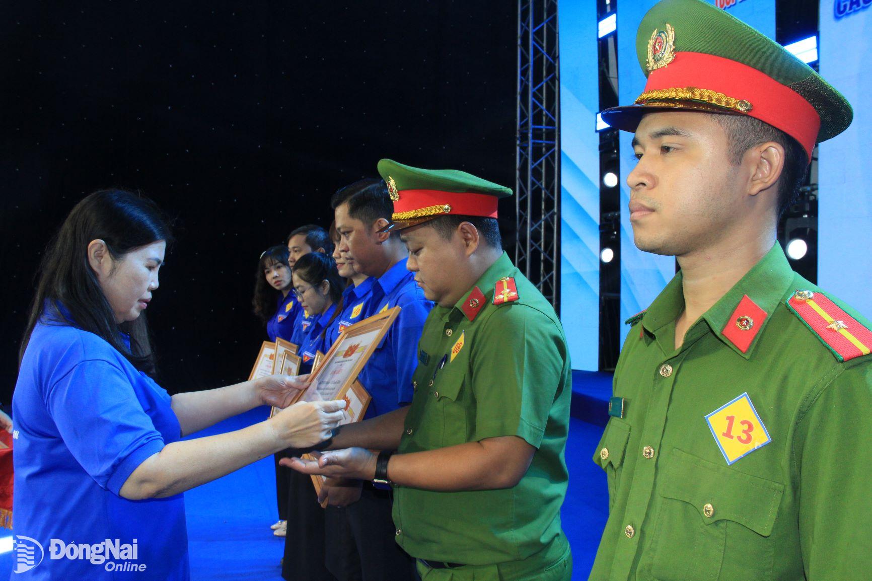 Phó trưởng ban thường trực Ban Dân vận Tỉnh ủy Phạm Thị Kim Chung trao bằng khen cho các tập thể có thành tích xuất sắc trong phong trào Thanh niên tình nguyện hè. Ảnh: Nga Sơn