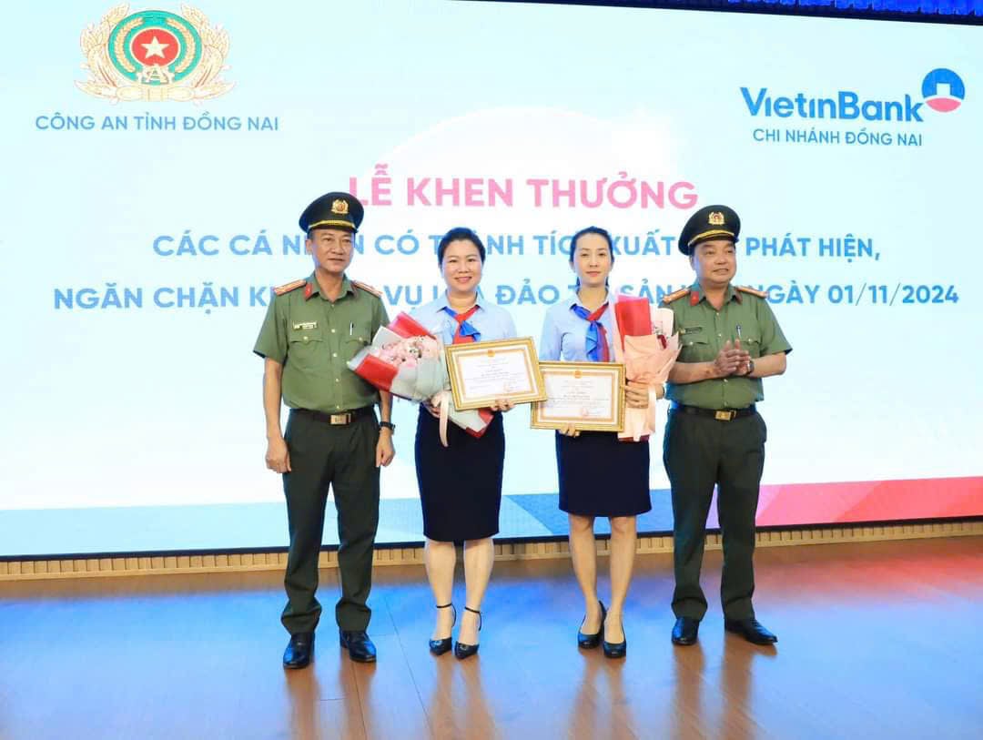 Đại diện Công an tỉnh trao giấy khen của Giám đốc Công an tỉnh cho hai nhân viên ngân hàng. Ảnh: Công an tỉnh