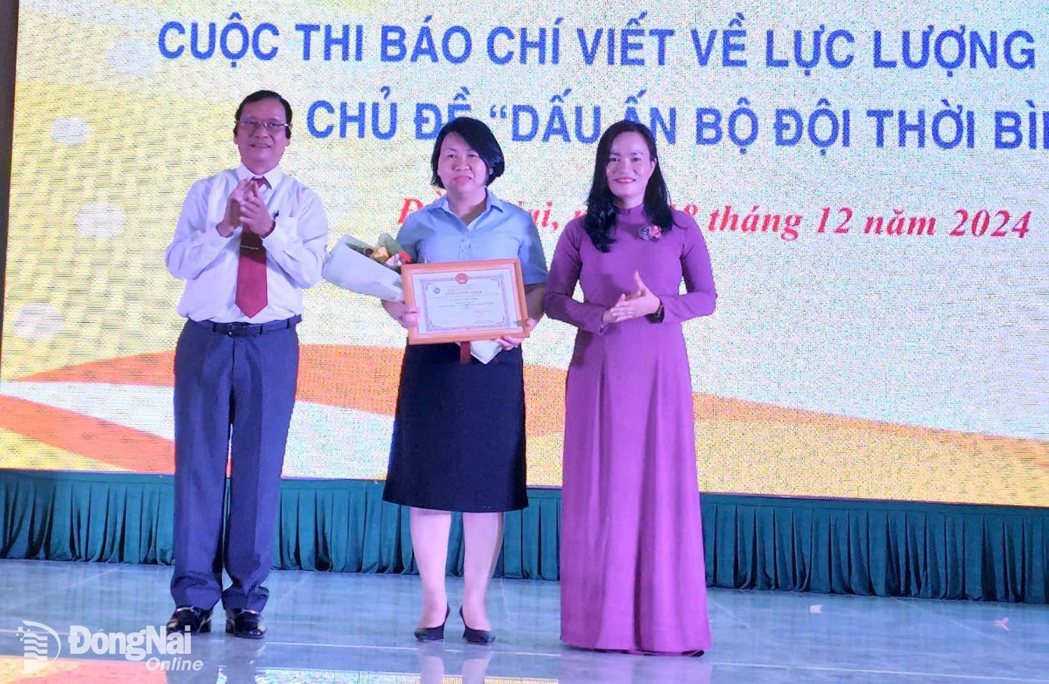 Ban tổ chức trao giải nhất Cuộc thi Dấu ấn bộ đội thời bình cho nhà báo Cù Thị Thuận - Báo Đồng Nai. Ảnh: Ly Na