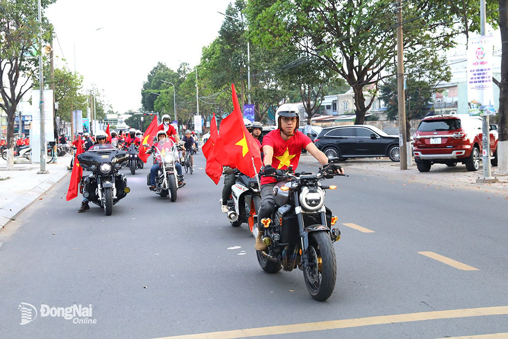 Các thành viên Câu lạc bộ mô-tô Biên Hòa mang theo cờ Tổ quốc diễu hành qua một số tuyến đường. Ảnh: Huy Anh