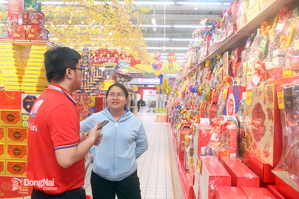 Người tiêu dùng tham khảo, chọn mua các mặt hàng phục vụ Tết tại một siêu thị ở thành phố Biên Hòa. ảnh: H.Quân