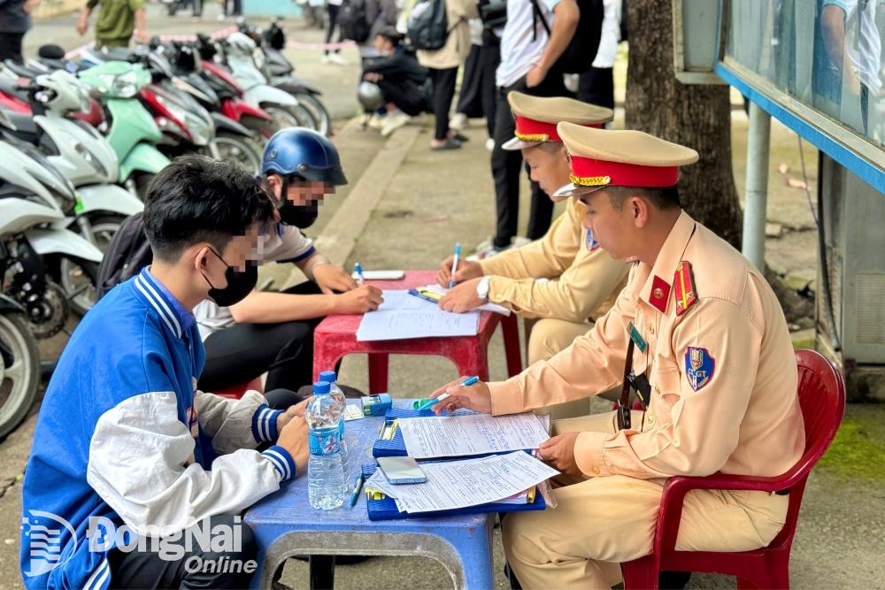 Đội Cảnh sát giao thông - trật tự Công an thành phố Biên Hòa lập biên bản các học sinh điều khiển xe máy khi chưa đủ điều kiện (độ tuổi và giấy phép lái xe). Ảnh: Minh Thành