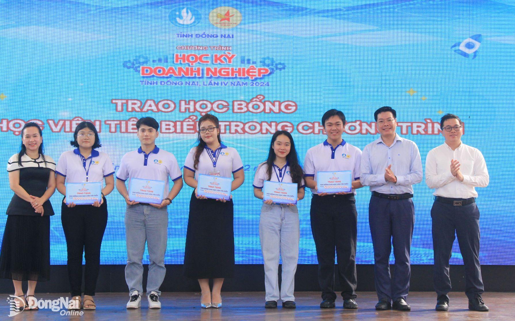 Các đại biểu trao học bổng cho 5 học viên tiêu biểu. Ảnh: Nga Sơn