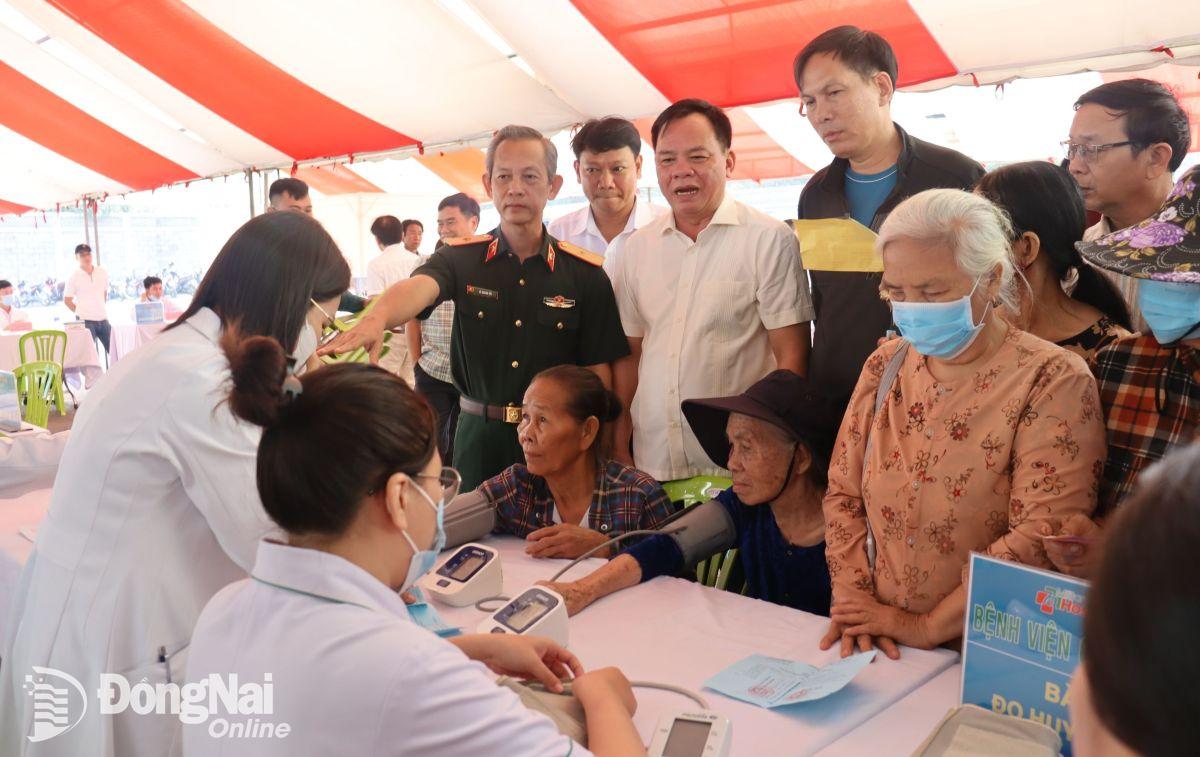 Bác sĩ Lê Quang Trí (thứ 2 trái qua) và Chủ tịch UBND tỉnh Võ Tấn Đức thăm, động viên người dân đến khám bệnh miễn phí. Ảnh: Nguyệt Hà