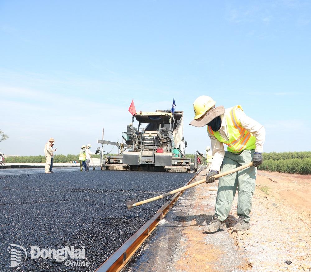 Theo nhà thầu là Công ty CP Lizen, trong buổi sáng, trời nắng, thời tiết thuận lợi cho việc thi công thảm bê tông nhựa. Ảnh: Phạm Tùng