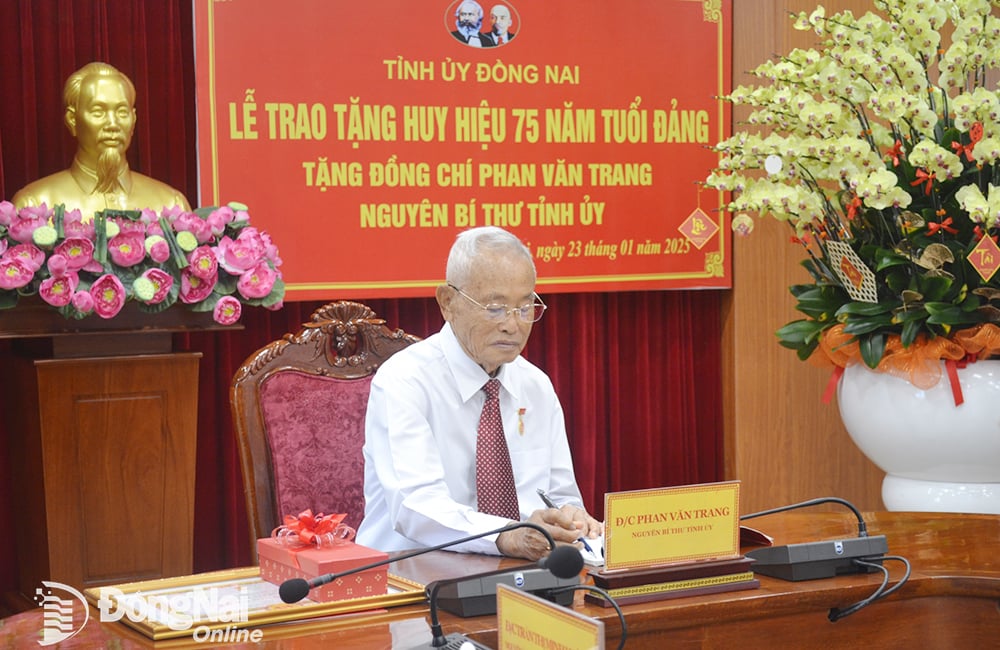 Nguyên Bí thư Tỉnh ủy Phan Văn Trang ký nhận sổ nhận Huy hiệu Đảng. Ảnh: Phương Hằng