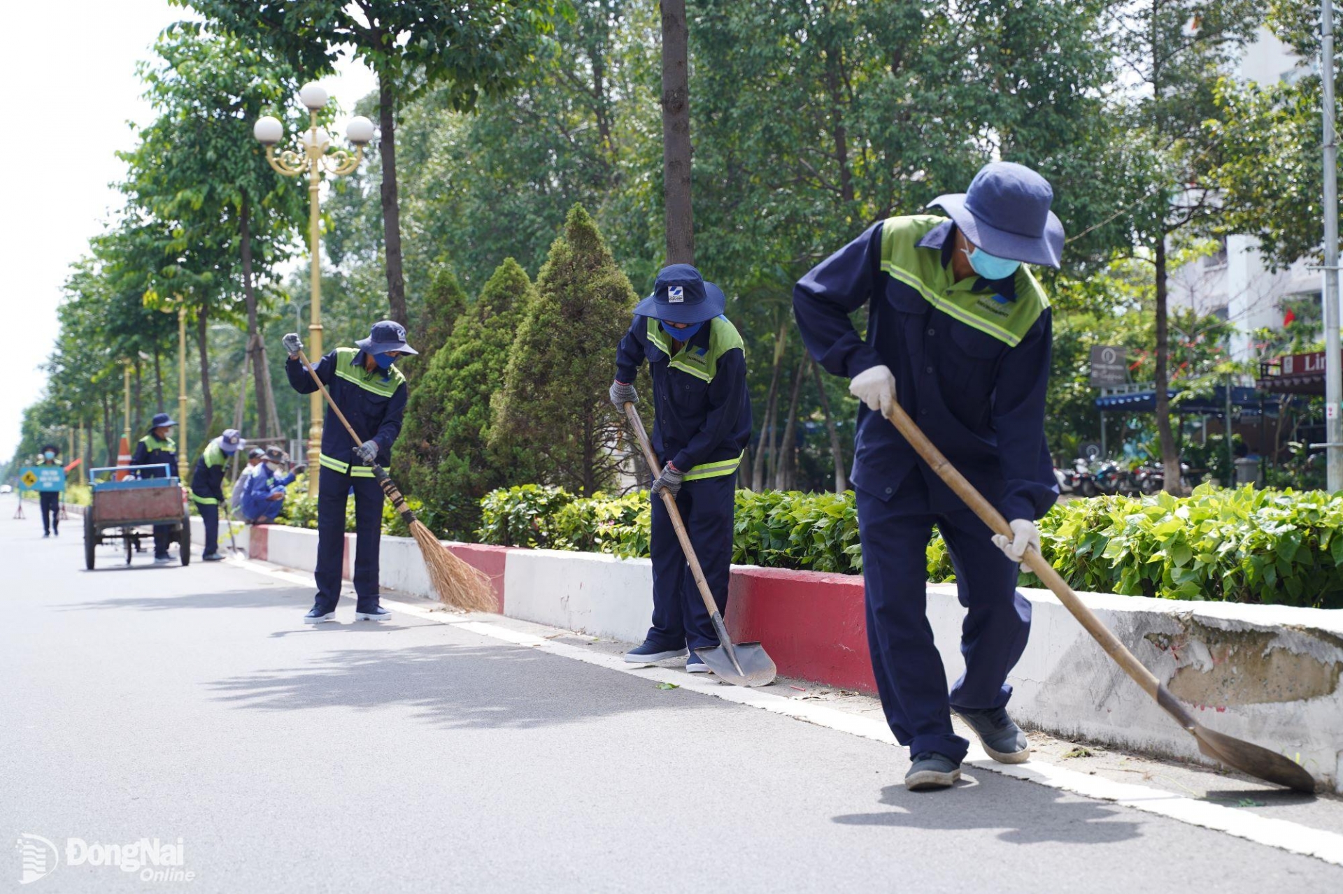 Công nhân Công ty CP Môi trường Sonadezi thực hiện vệ sinh lòng lề đường phố. Ảnh: Hoàng Lộc