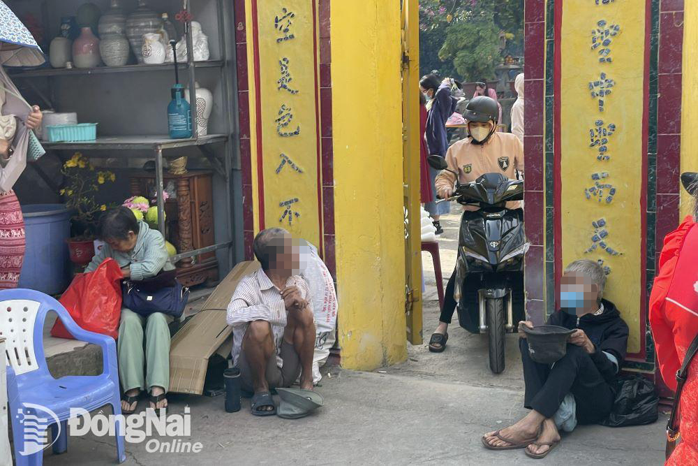 Người ăn xin ngồi trước cổng chùa Từ Tôn (phường Tam Hiệp) để xin tiền vào ngày Mùng 1. Ảnh Lê Duy