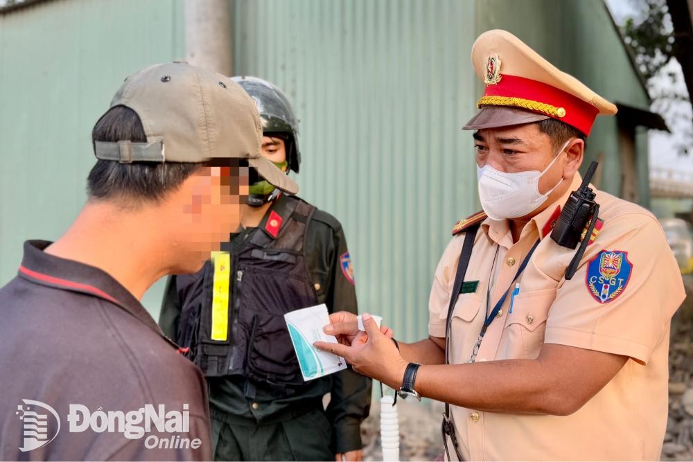 Đội Cảnh sát giao thông - trật tự Công an thành phố Biên Hòa hướng dẫn các tài xế cách thử chất ma túy trong cơ thể trên đường chuyên dùng vào cụm mỏ đá Tân Cang (phường Phước Tân, thành phố Biên Hòa). Ảnh: Đăng Tùng 