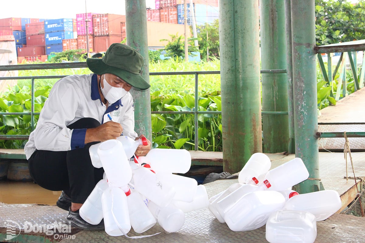 Công nhân Trung tâm Kỹ thuật tài nguyên và môi trường Đồng Nai chuẩn bị lấy mẫu nước quan trắc. Ảnh: H.LỘC