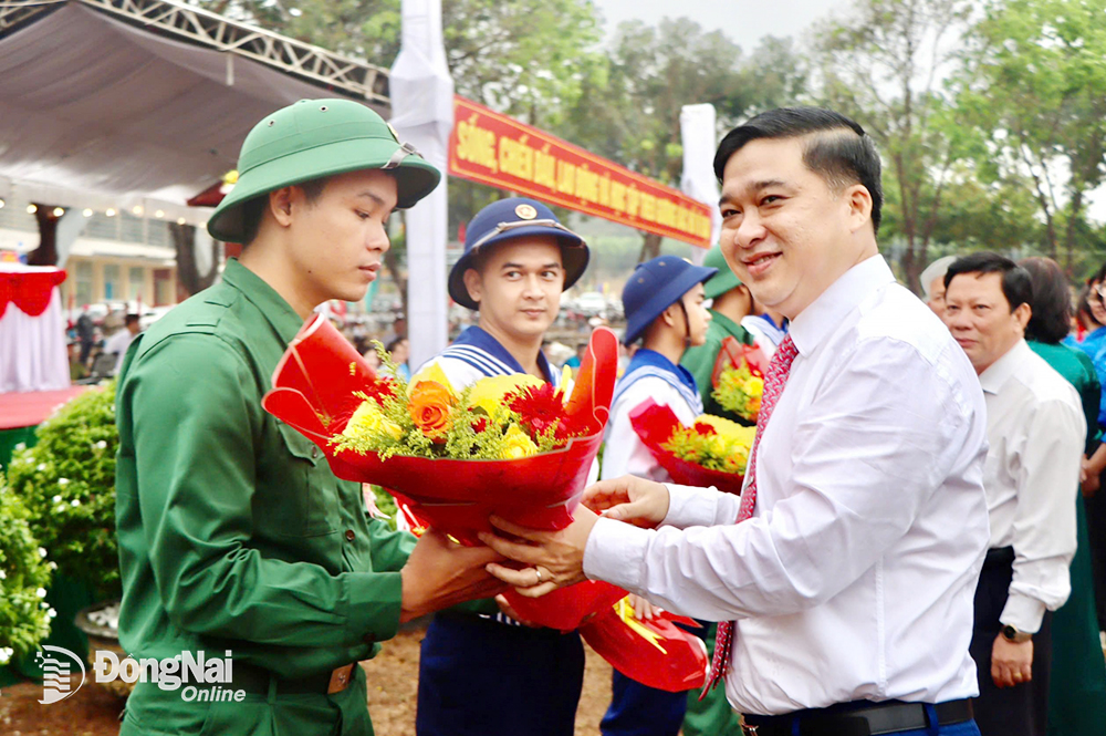 Phó chủ tịch UBND tỉnh Hồ Văn Hà tặng hoa cho đảng viên trẻ lên đường nhập ngũ. Ảnh: Hải Đình 