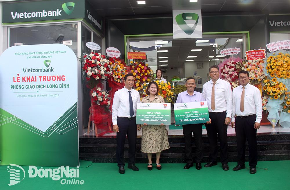 Đại diện Vietcombank chi nhánh Đồng Nai và Phòng giao dịch Long Bình trao tặng bảng hiện kim tổng số tiền 70 triệu đồng dành cho công tác an sinh xã hội cho đại diện Ủy ban MTTQ Việt Nam thành phố Biên Hòa và UBND phường Long Bình. Ảnh: Hải Quân