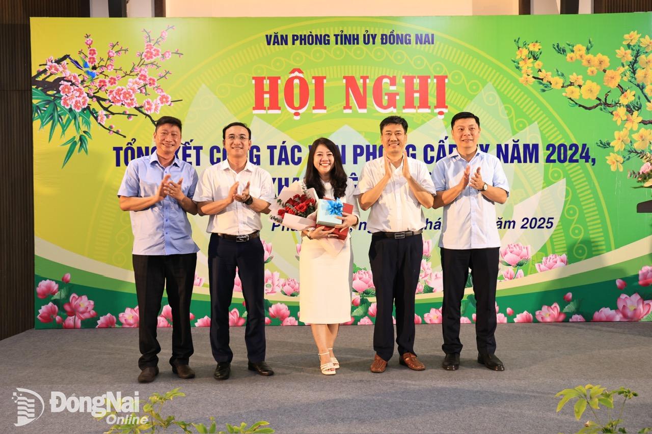 Tập thể lãnh đạo Văn phòng Tỉnh ủy tặng hoa chúc mừng đồng chí Trần Thanh Đan Châu, nguyên Trưởng phòng Tổng hợp Văn phòng Tỉnh ủy đã được Ban Thường vụ Tỉnh ủy chỉ định tham gia Ban Chấp hành Huyện ủy Vĩnh Cửu. Ảnh: Công Nghĩa