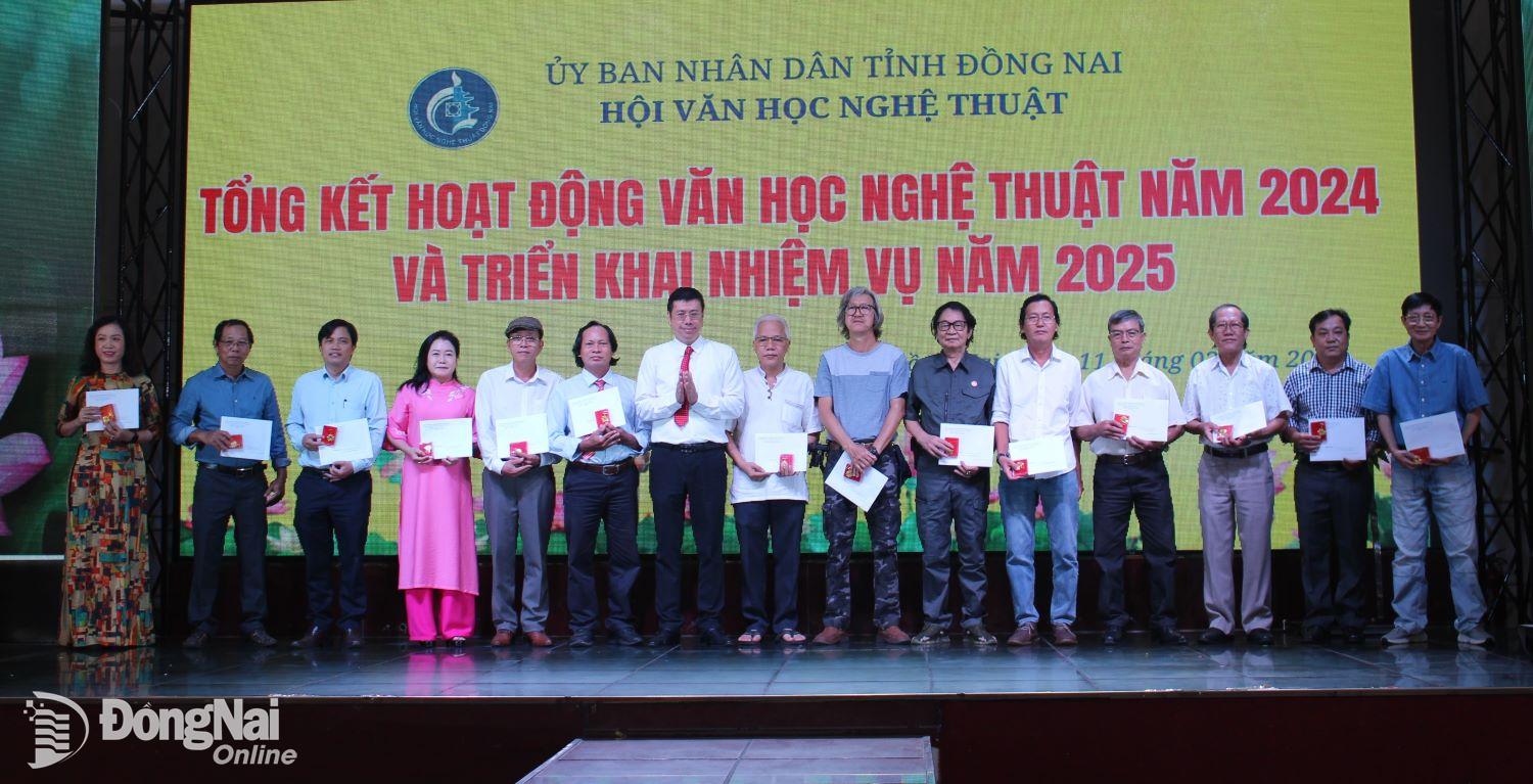 Đại diện lãnh đạo Ủy ban Liên hiệp các Hội Văn học nghệ thuật Việt Nam khu vực phía Nam trao kỷ niệm chương cho các hội viên. Ảnh: My Ny