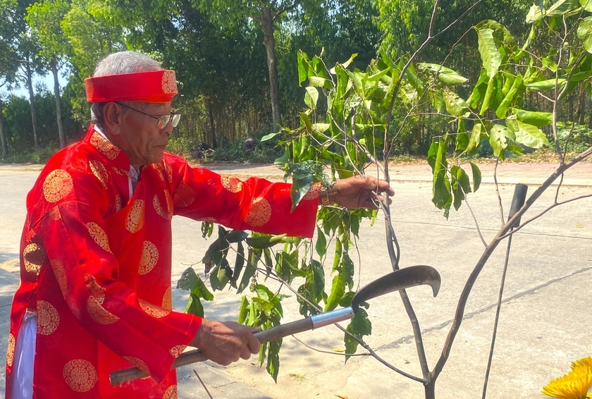 Kết thúc nghi thức cúng Khai Sơn, ông Trần Thái Dũng-Chánh bài Ban nghi lễ miếu An Xuyên (phường Tây Sơn, thị xã An Khê) chặt tượng trưng cành cây đặt trước ban cúng, thay lời cáo xin thần linh cho mở cửa rừng đầu năm gặp thuận lợi. Ảnh: Ngọc Minh