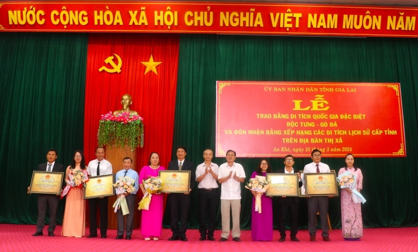 Ông Trần Ngọc Nhung (thứ 5 bên phải)-Giám đốc Sở Văn hóa-Thể thao và Du lịch tỉnh và ông Nguyễn Hùng Vỹ (thứ 6 bên phải)-Phó Bí thư Thường trực Thị ủy, Chủ tịch HĐND thị xã An Khê tặng hoa, trao bằng xếp hạng di tích cấp tỉnh cho xã, phường có di tích được xếp hạng. Ảnh: Ngọc Minh