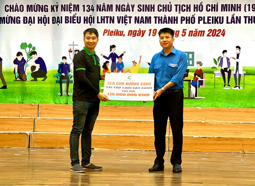 Bí thư Thành Đoàn Pleiku Thái Giang Nam (bìa phải) nhận bảng tượng trưng 3.800 cây xanh từ Câu lạc bộ Con đường xanh. Ảnh: P.L